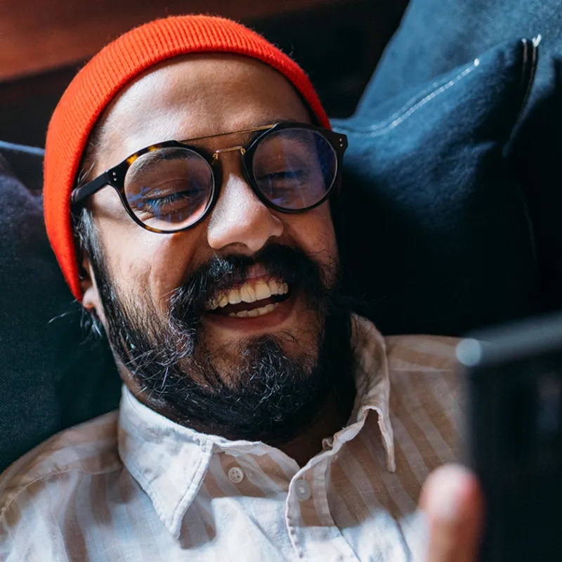 Mann lachend auf dem Sofa Mann lachend auf dem Sofa